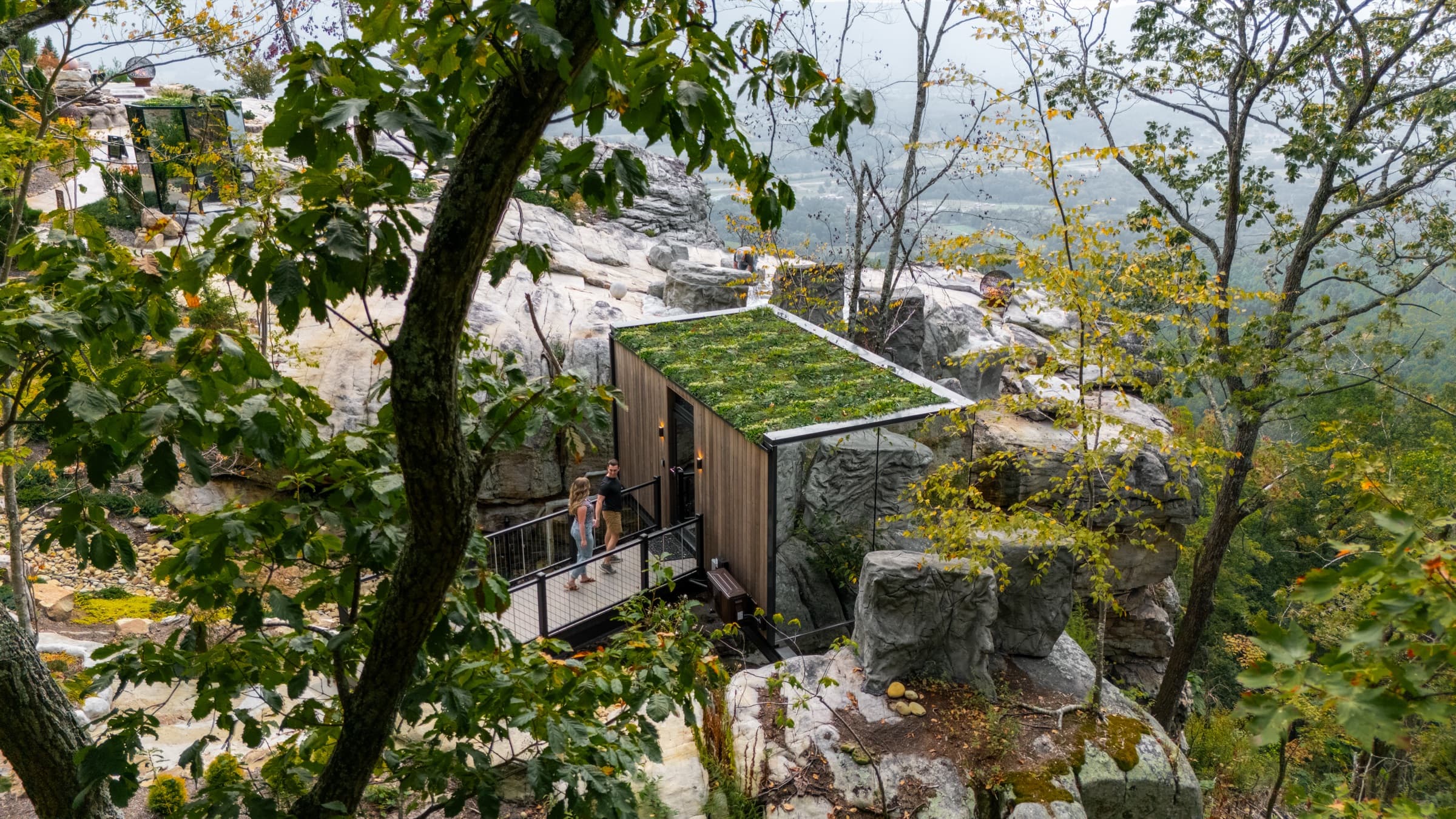 A couple on the deck of a BOLT FARM mirror cabin above the valley